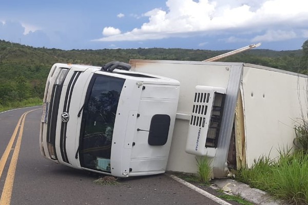 Motorista e passageiro ficam feridos após caminhão carregado de frios tombar na LMG 740