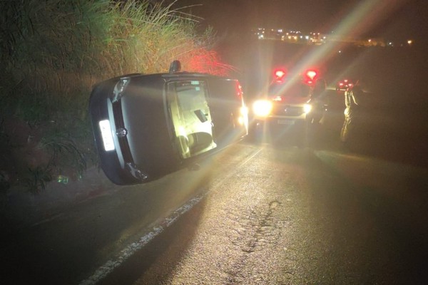 Passageiro fica ferido após motorista atingir canaleta, rodar na pista e tombar veículo na MGC-354 em Patos de Minas