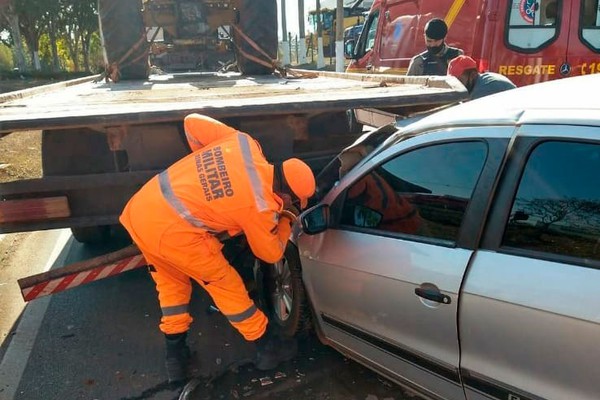 Carro fica destruído ao se chocar em caminhão prancha na Avenida JK