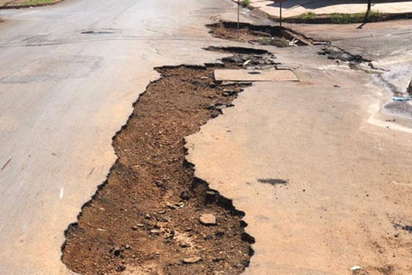 Carro fica preso em buraco e moradores fazem cartazes para cobrar providências