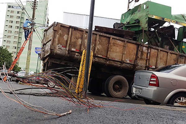 Caminhão transportando máquina agrícola danifica fiação e causa transtorno na região central