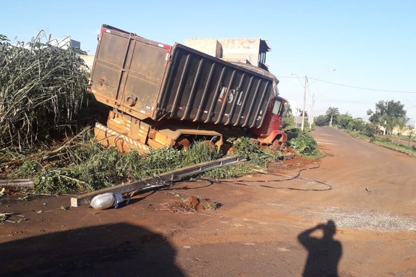 Motorista fica ferido após caminhão perder freio, subir em rotatória e bater em poste em Patos de Minas