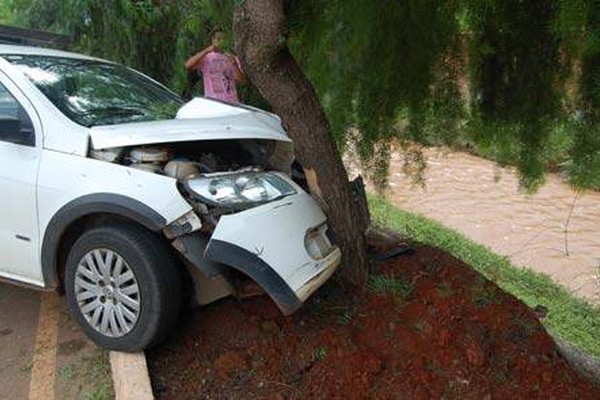 Senhor perde o controle, bate em árvore e por pouco não cai dentro de córrego