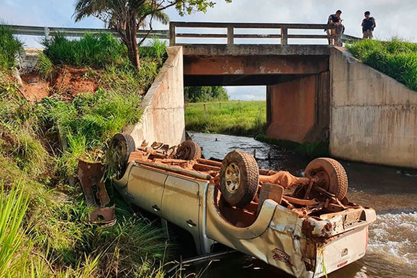 Caminhonete com duas pessoas fica com as rodas para o alto ao cair dentro de rio na MG230