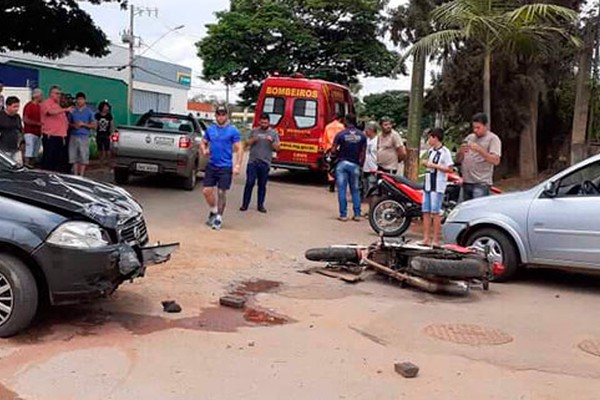 Motorista tem visão prejudicada por árvores, bate em motociclista que é arremessado em outro carro