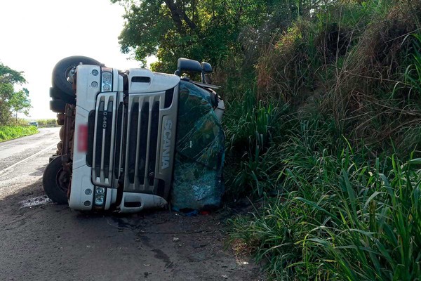 Motorista é socorrido após carreta carregada de ração tombar na MG 187