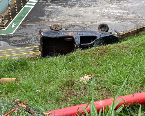 Motorista perde o controle de carro, invade empresa e vai parar tombado em barranco, em Patos de Minas