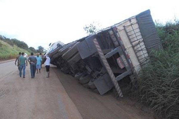 Caminhão carregado com MDF tenta desviar de buraco gigante e tomba na BR 365