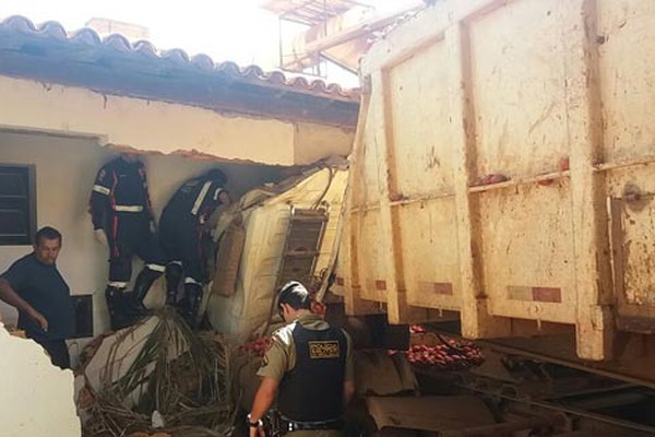 Carreta sem freio arranca árvores, invade motel e motorista fica preso às ferragens