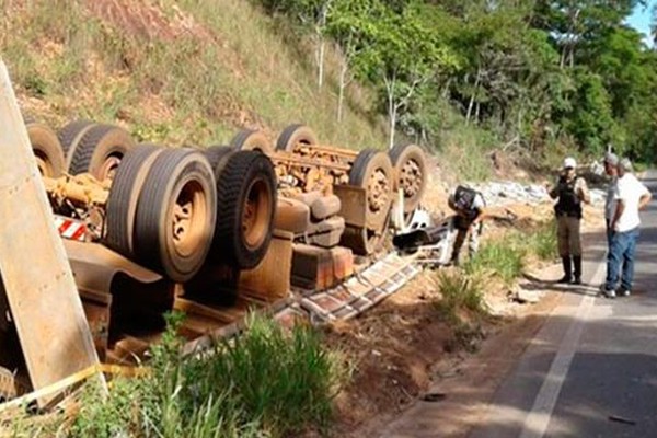 Motorista morre após caminhão carregado com grama capotar na MGC 354