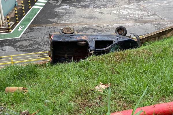 Motorista perde o controle de carro, invade empresa e vai parar tombado em barranco, em Patos de Minas