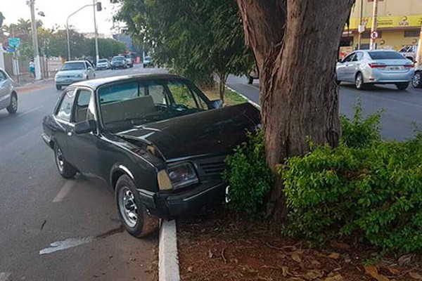 Motorista perde o controle do carro ao passar em terra e acaba em árvore de avenida