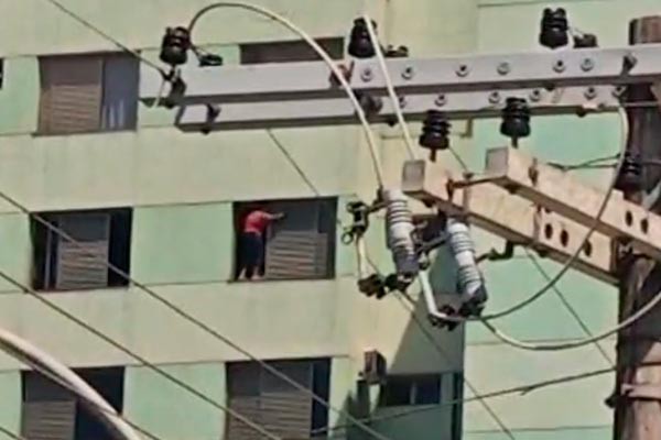 Mulher se arrisca no alto de prédio de quase 15 andares limpando janela sem proteção, em Patos de Minas